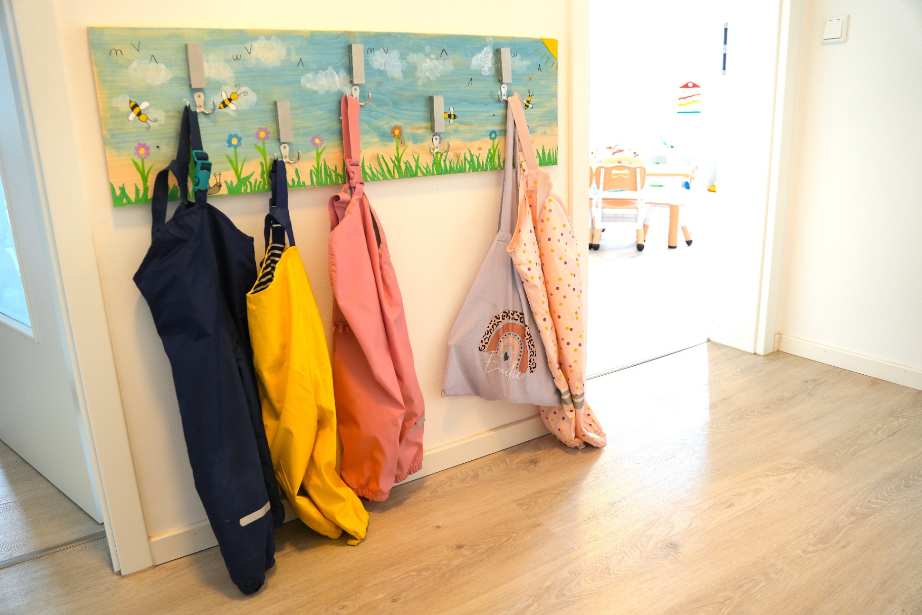 Handbemalte Garderobe mit Matschhosen der Kinder